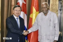 古巴全国人民政权代表大会主席拉索与越南驻古巴新任大使黎光龙握手。