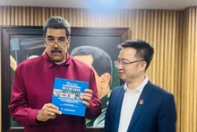 马杜罗总统接收由阮祥林赠送的《世界人民对胡志明主席的感情》（西班牙语版）书籍。（图片来源：越通社）