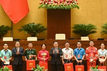 国会主席王廷惠和越南劳动总联合会主席阮廷康向取得成绩优异的工会会员和贫困劳动者赠送礼品。