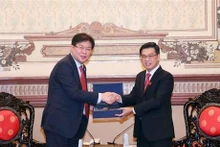 胡志明市人民议会副主席阮文勇（右）与韩国釜山市议会议长安成敏。（图片来源：越通社）