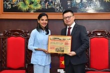 古巴《格拉玛报》社副总编辑阿尔林·阿尔贝蒂·洛福尔特向黎国明同志赠送纪念品。（水原 摄）