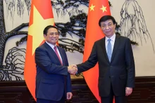 越南政府总理范明正见中共中央政治局常委、全国政协主席王沪宁。（图片来源：VGP）