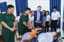 越南国防部副部长黄春战上将与美国驻越大使马克·纳珀走访慰问河内市巴维县安牌乡护理、抚养和治疗橙剂/二恶英受害者中心的受害者。（图片来源：越通社）