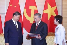 苏林总书记向中共中央总书记、国家主席习近平赠送越南通讯社出版有关习近平同志历次访越的画册。（图片来源：越通社）