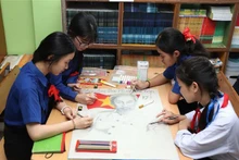 阮攸老越双语学校学生正在画胡伯伯肖像。