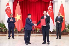 越南计划与投资部长阮志勇与新加坡贸工部第二部长兼人力部长陈诗龙签署越新绿色经济-数字经济伙伴关系谅解备忘录。