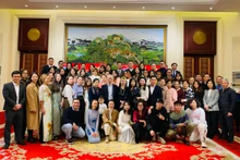 越南驻华大使馆馆员同旅居中国越南人代表合影。（杜有兴 摄）