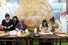 越新两国政府总理夫人参观布贴画合作社。（图片来源：越通社）