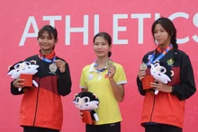 越南田径运动员黎氏雪梅（中）在女子400米比赛中获得金牌。