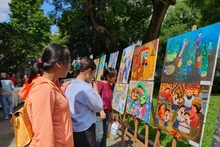 与会代表观看参加“绿色东盟：今天的环境，未来的生活”绘画比赛的作品。