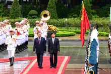 老挝人民革命党中央总书记、国家主席通伦·西苏里和越共中央总书记、国家主席苏林检阅仪仗队。