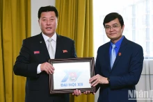 裴光辉同志向文哲同志赠送纪念品。