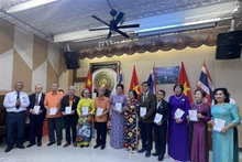 前越南国家副主席张美华向旅居泰国乌隆府越南人协会和33名旅居乌隆府越南人颁发会员证书。（图片来源：越通社）