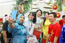 各国劳动者和工人在越南展区合影留念。（图片来源：越通社）