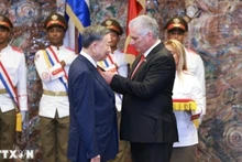 古共中央第一书记、国家主席米格尔·迪亚斯-卡内尔·贝穆德斯向越共中央总书记、国家主席苏林颁授“何塞·马蒂”勋章。（图片来源：越通社）