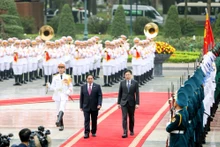 范明正总理和新加坡总理黄循财检阅仪仗队。（图片来源：VGP）