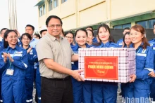 越南政府总理范明正向宜山炼油厂工程师和工人赠送礼物。