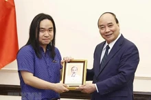 越南国家主席阮春福在主席府会见了在美越南留学生、文学领域青年人才阮平。（图片来源：越通社）