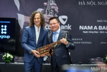 肯尼·基向《人民报》社总编辑黎国明赠送与他事业息息相关的一把萨克斯管。