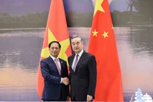 越南外交部长裴青山与中国外交部长王毅。(图片来源:国际报)