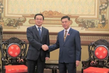 胡志明市人民委员会副主席阮文勇（右）和中国浙江省人大常委会副主任高兴夫亲切握手。