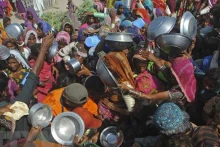 附图：在巴基斯坦信德省受洪水影响的地区的民众聚集领取粮食援助。（图片来源：法新社/越通社）