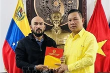 越南驻委内瑞拉大使向何塞·哈维尔·迪亚斯·马卡丹教授赠送纪念品。（图片来源：越通社）