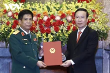 越南国家主席武文赏向越南人民军副总参谋长阮文义中将颁发晋升上将军衔的决定书。