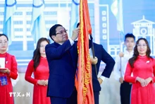 范明正总理代表党和国家领导人向胡志明市国家大学颁发一级劳动勋章。（图片来源：越通社）