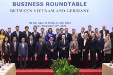 越南政府总理范明正和德国总理奥拉夫·朔尔茨同两国企业合影。