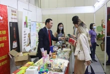 越南驻新加坡商务处首席代表高春胜向国际企业代表介绍越南产品。
