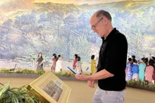 外国游客扫描二维码了解奠边府战役全景画。