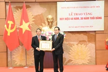 越南国会主席陈青敏向越南国会副主席阮德海同志授予40年党龄纪念章。