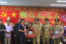 永隆省人民委员会副主席阮文烈接受由柬埔寨磅士卑省赠送的礼物。（图片来源：越通社）