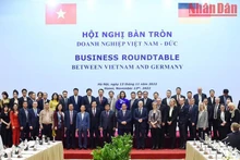 越南政府总理范明正和德国总理奥拉夫·朔尔茨同越德企业代表合影。（陈海 摄）
