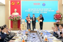 黎国明同志向越南卫生部长陶红兰和卫生部副部长陈文瞬授予“致力于人民报事业”纪念章。（世大 摄）