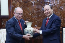 国家主席阮春福向德国世界大学服务机构主席赠送礼物。