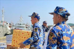 官兵们将年货装船。（图片来源：越通社）