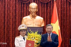 越共中央总书记、国家主席、人民武装力量统帅、国防与安全委员会主席苏林向越共中央委员、中央公安党委常务委员会委员、公安部副部长邓鸿德授予晋升上将军衔决定。（图片来源：越通社）