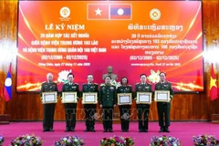 老挝国防部副部长、老挝人民军总政治局主任冯松•英潘平上将向越南108中央军队医院的个人授予老挝国家的劳动勋章。（图片来源：越通社）