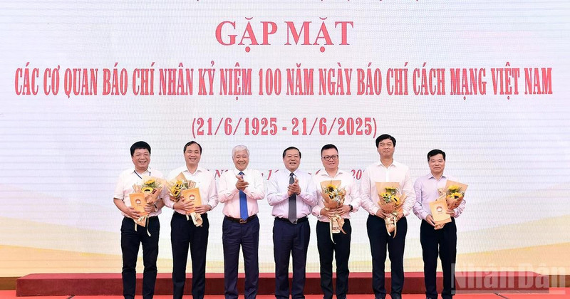 越南祖国阵线中央委员会主席杜文战与越共中央宣教与民运部常务副部长赖春门（左三、左四）在活动中向新闻机构领导代表赠送鲜花。