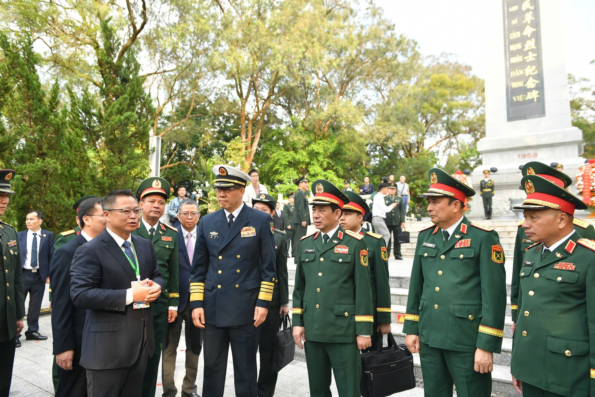 潘文江大将与董军上将以及两国各位代表倾听关于越中人民革命烈士纪念碑的介绍。