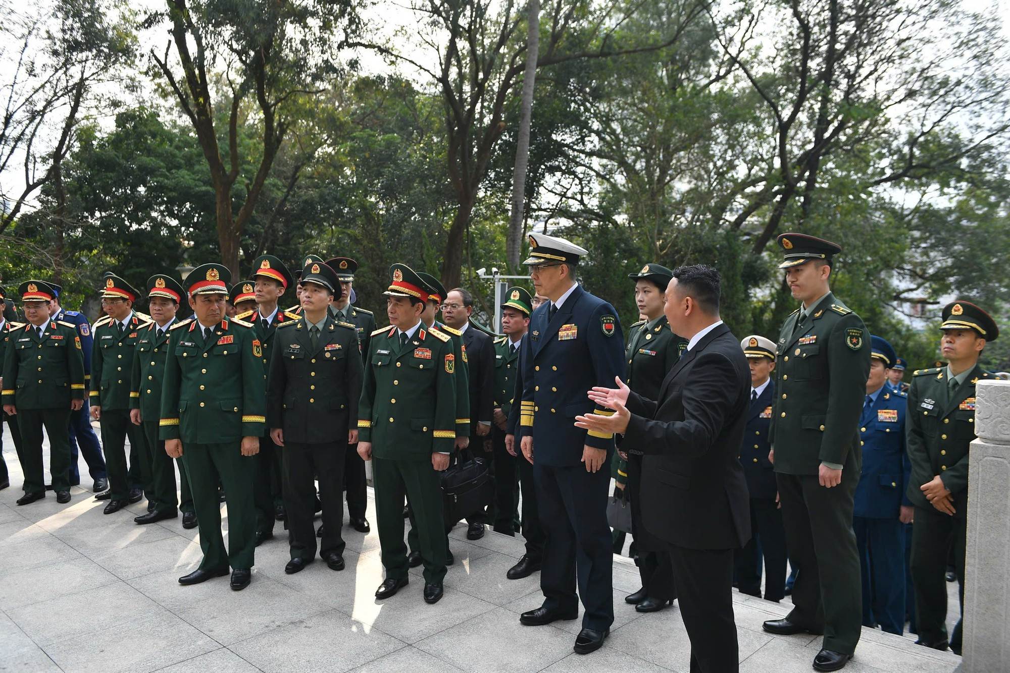 潘文江大将与董军上将以及两国各位代表倾听关于越中人民革命烈士纪念碑的介绍。