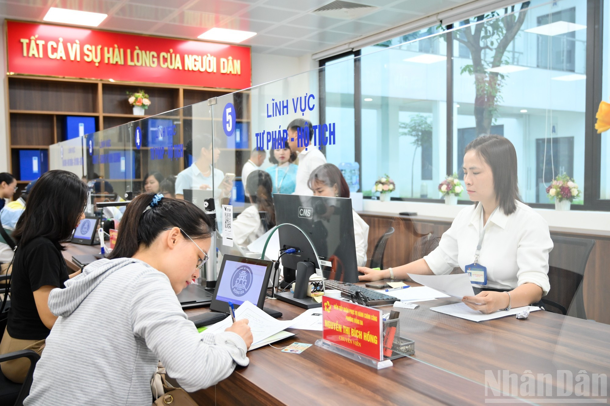 当他们的号码到达时，人民会去接待处并与接待员一起工作。