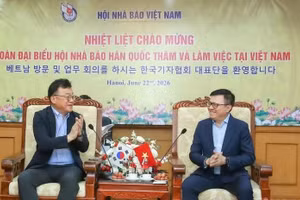 越共中央委员、《人民报》总编辑、越南新闻工作者协会主席黎国明（右）与韩国记者协会会长朴钟贤。（图片来源：越通社）