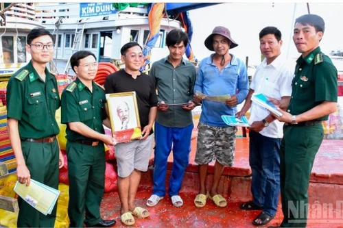 芹苴市边防部队指挥部向渔民赠送国旗和胡伯伯的照片。（图片来源：越通社）