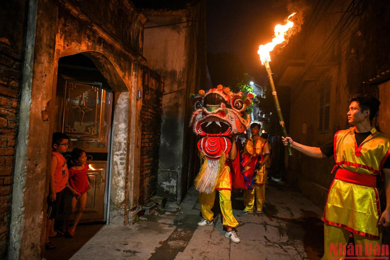 麟舞表演节目结束后，麟舞队成员在村里游行。