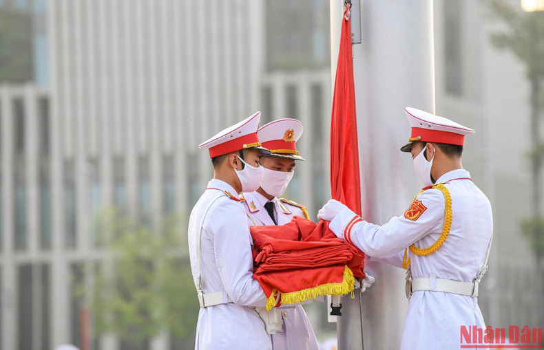 5时59分，标兵战士举起国旗挂在旗杆上。