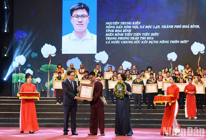 国会副主席陈青敏和内务部部长范氏青茶向和平省先进模范农民阮忠坚授予奖状和赠送鲜花。（陈海 摄）