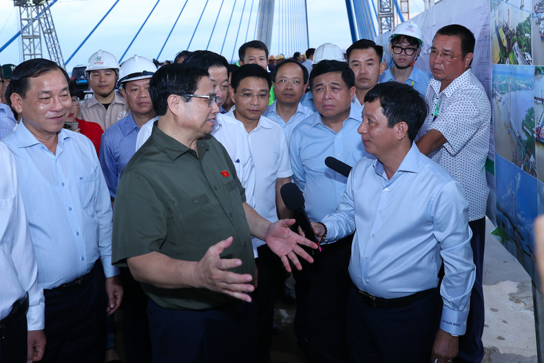 越南政府总理范明正与美顺二号大桥的工程师和工人交流。（图片来源：VGP）